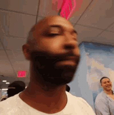 Man With Beard And White Shirt In Front Of Exit Sign GIF