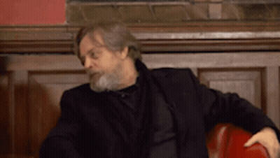 Man With Beard in Black Jacket Sitting in Red Chair