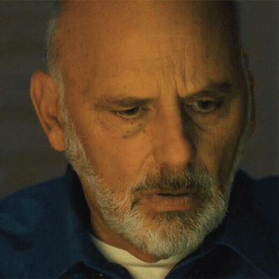 Man With Beard In Blue Shirt Looking Down GIF