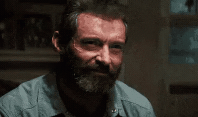 Man With Beard In Blue Shirt Sitting At Table GIF