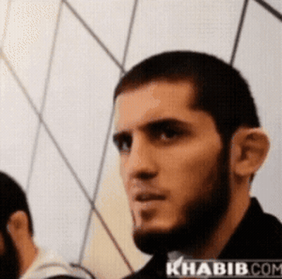 Man With Beard In Front Of Khabib.com Wall GIF
