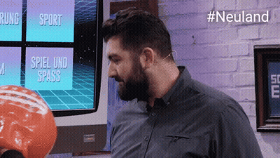 Man With Beard In Front Of TV Saying Spiel Und Spass GIF