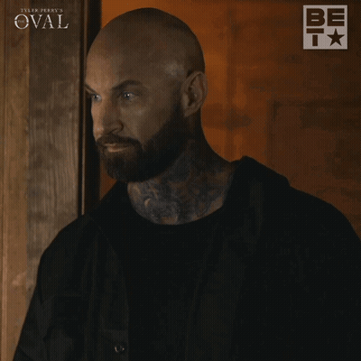 Man With Beard In Front Of Tyler Perry's Oval Sign GIF