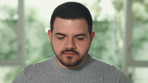 Man With Beard In Grey Shirt Looking Down GIF