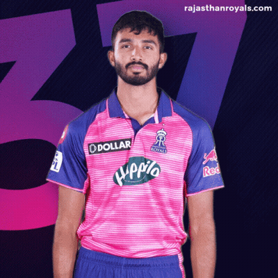 Man With Beard In Pink And Blue Jersey Saying Dollar GIF