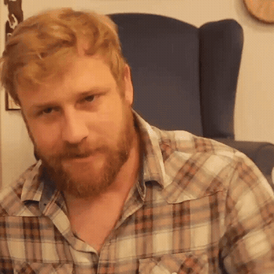 Man With Beard In Plaid Shirt Sitting In Chair GIF