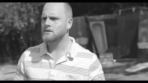 Man With Beard In Striped Shirt Looking At Camera GIF