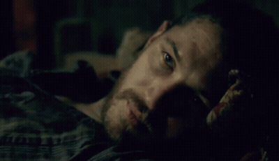 Man With Beard Laying On Bed In Dark GIF