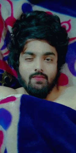 Man With Beard Laying Under Blue Blanket Eyes Closed GIF