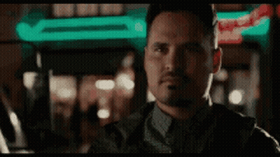 Man With Beard Looking At Camera In Front Of Neon Sign GIF