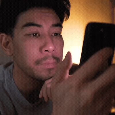 Man With Beard Looking At Cell Phone In Dark GIF