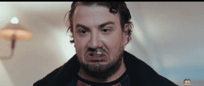 Man With Beard Making Funny Face With Glass In Mouth GIF