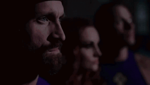 Man With Beard Next To Two Women In Purple Shirts GIF