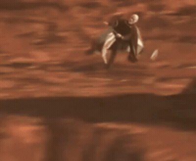 Man With Beard Riding Scooter In Sand GIF