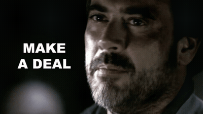 Man With Beard Says Make A Deal In Dark Room GIF