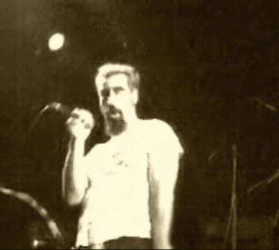 Man With Beard Singing Into Microphone On Stage GIF
