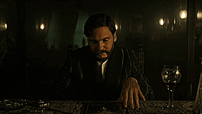 Man With Beard Sitting At Table With Wine Glass GIF