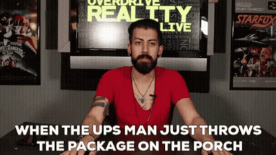 Man With Beard Sitting In Front Of Overdrive Reality Live Sign GIF
