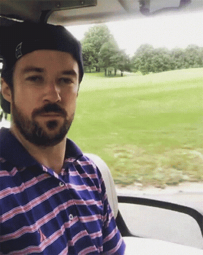 Man With Beard Sitting In Golf Cart Looking At Camera GIF