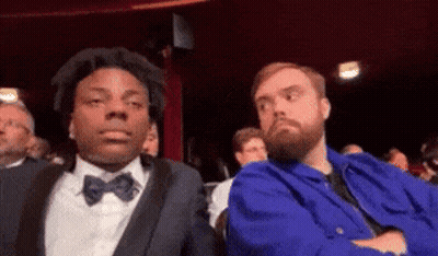 Man With Beard Sitting Next To Man In Blue Jacket GIF