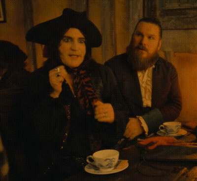 Man With Beard Sitting Next To Woman In Black Hat GIF