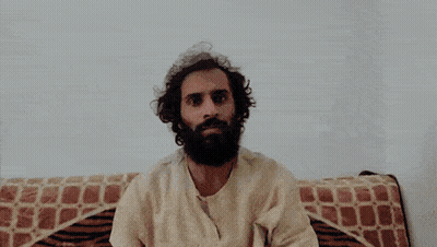 Man With Beard Sitting On Couch With Blanket On Head GIF