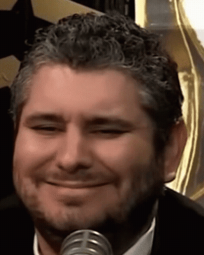 Man With Beard Smiling At Microphone In Suit And Tie GIF