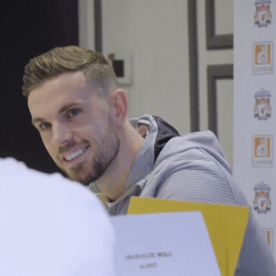 Man With Beard Smiling In Front Of Liverpool FC Sign GIF