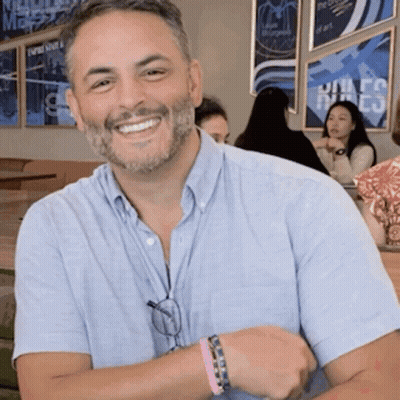 Man With Beard Smiling In Front Of United States Sign GIF