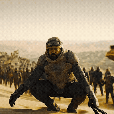 Man With Beard Squatting In Desert GIF