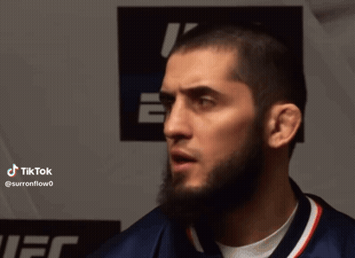 Man With Beard Standing In Front Of Tik Tok Sign GIF