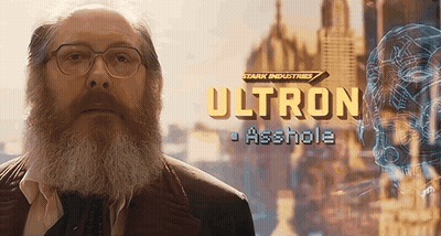 Hombre con barba parado frente a letrero de Ultron GIF