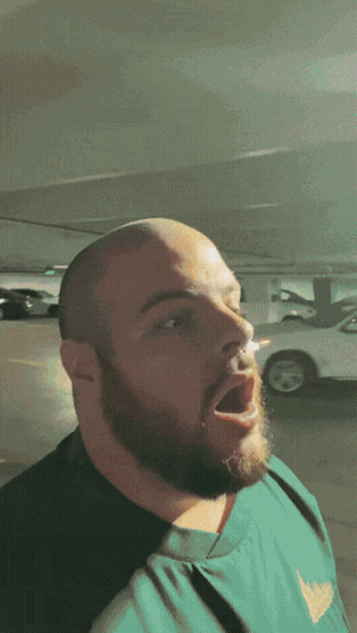 Man With Beard Standing In Parking Lot Mouth Open GIF