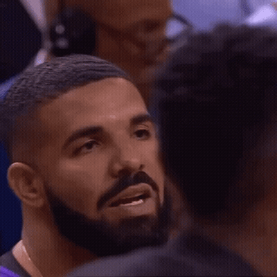 Man With Beard Talking To Another In Crowd GIF