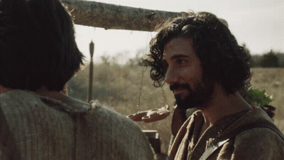Man With Beard Talking To Another Man Holding Candle GIF