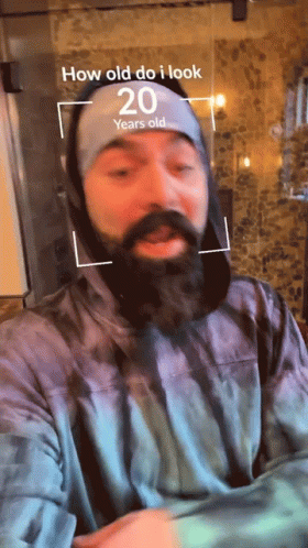 Man With Beard Wearing Headband That Says How Old Do I Look GIF