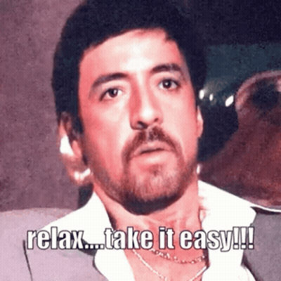 Man With Beard Wearing Suit And Necklace Says Relax GIF
