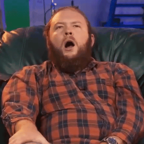Man With Beard Yawning In Plaid Shirt GIF