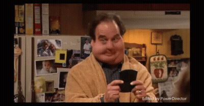 Man With Big Face Holding Wallet In Front Of Refrigerator With Pictures GIF
