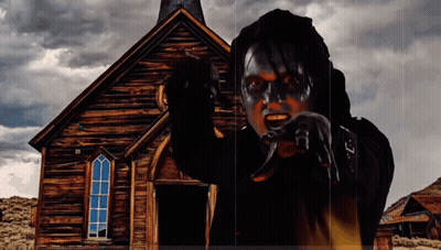 Man With Black Paint On Face In Front Of Old Wooden Church GIF