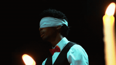 Man With Blindfold In Front Of Candles GIF