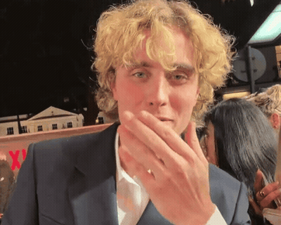Man With Blonde Curly Hair Covering Mouth GIF