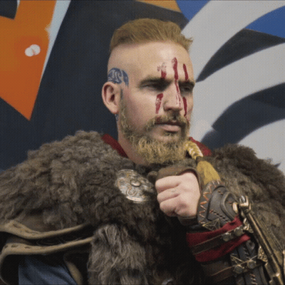 Man With Blood On Face And Beard In Fur Coat Holding Sword GIF