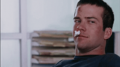 Man With Bloody Nose Sitting In Front Of Books GIF
