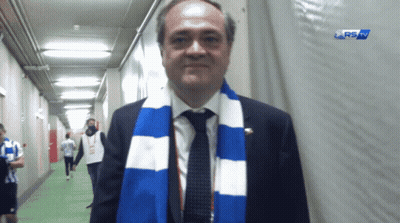 Man With Blue And White Scarf In Hallway RS Sign GIF