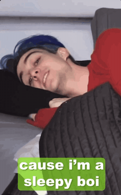Man with Blue Hair Laying on Bed Saying Cause I'm a Sleepy Bo