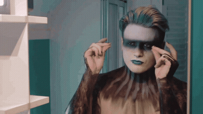Man With Blue Makeup Looking In Mirror GIF