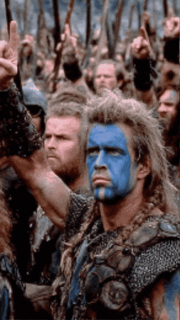 Man With Blue Paint On Face In Front Of Crowd GIF