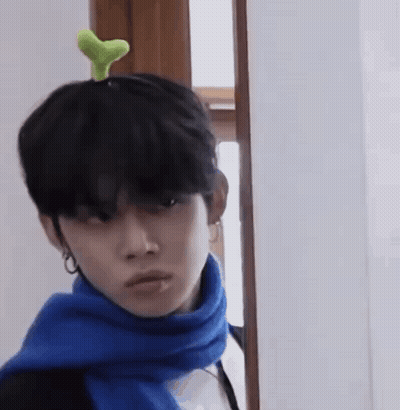 Man With Blue Scarf And Green Plant On Head GIF