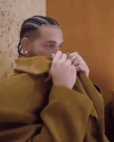 Man With Braids And Earrings Covering Face With Blanket GIF